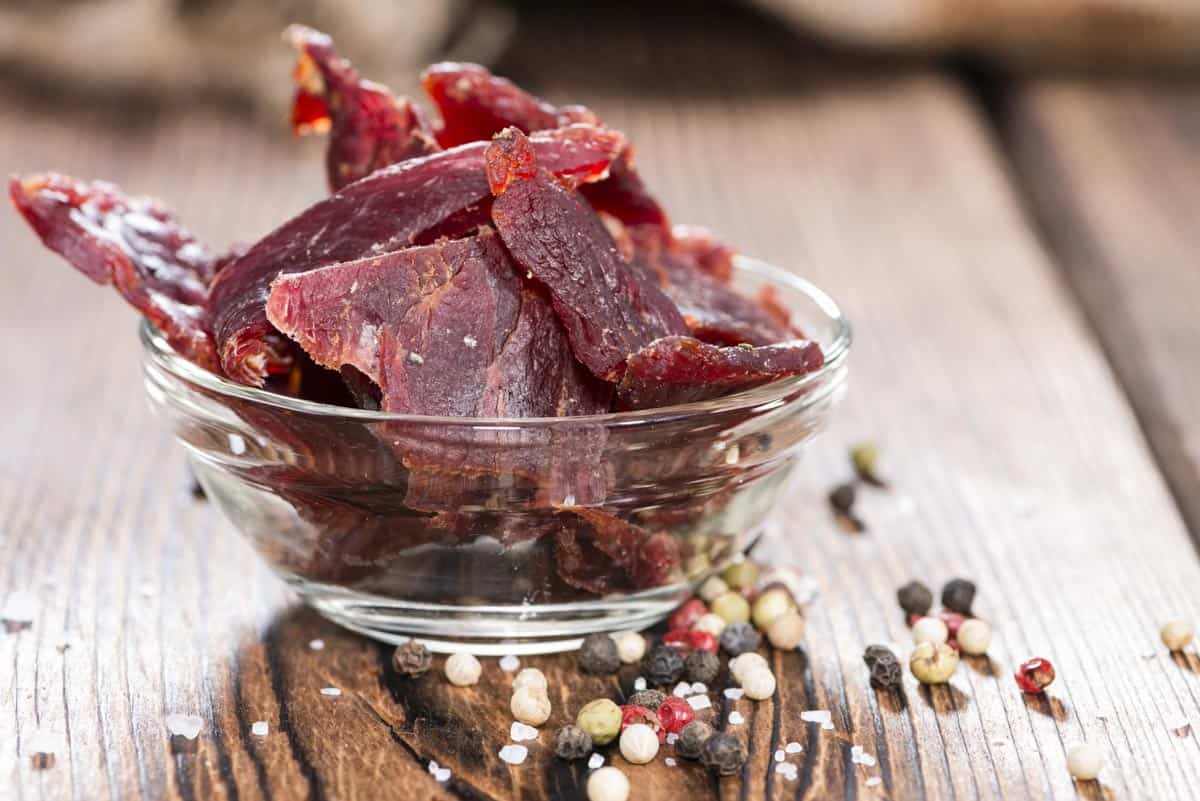 Smoked beef jerky in bowl with seasonings at base
