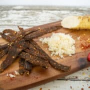 Beef jerky on cutting board with grated horseradish