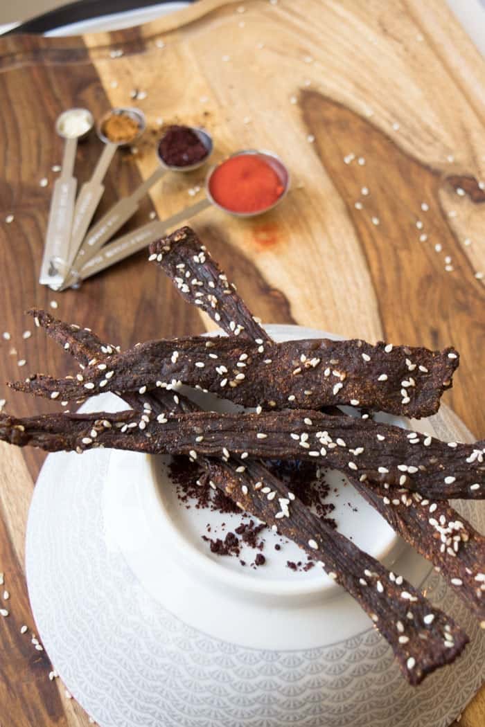 Beef jerky with sesame seeds on cutting board