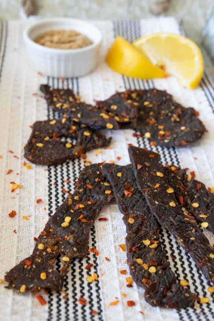 Spicy Sweet beef jerky finished on a towel with lemons and brown sugar