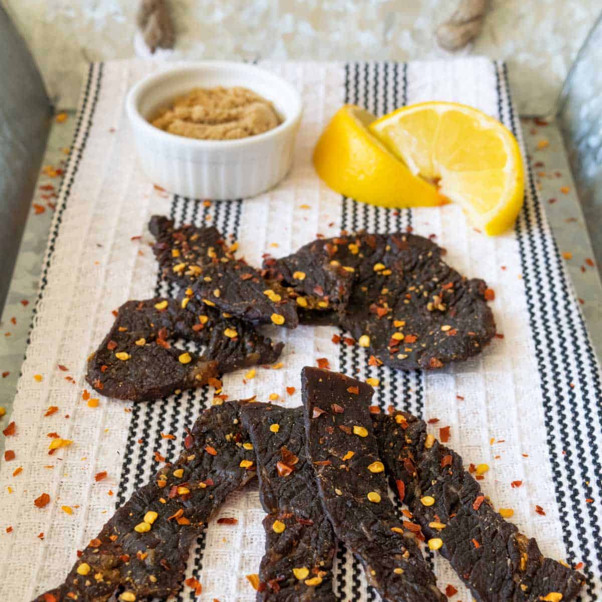 beef jerky on tray with lemons and spices