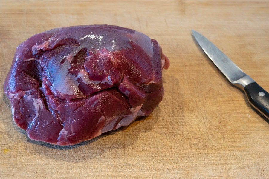 Venison roast on cutting board with knife