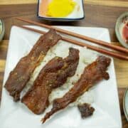 Pork jerky atop rice with korean small plates around