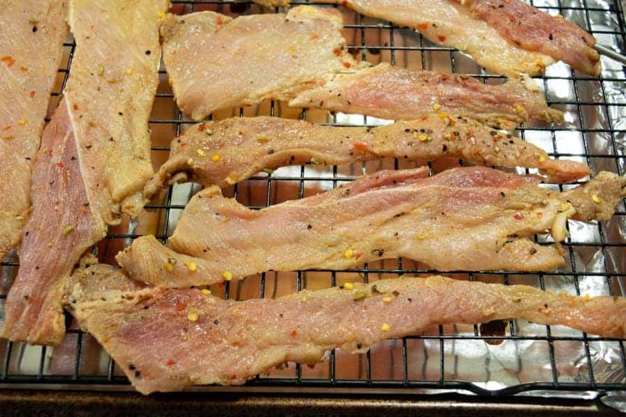Italian pork jerky strips on baking sheet
