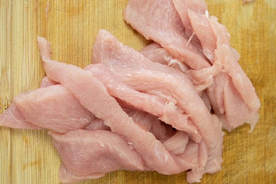 Turkey breast sliced for jerky on cutting board