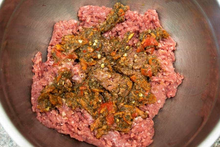 spicy ingredients on top of ground beef for jerky