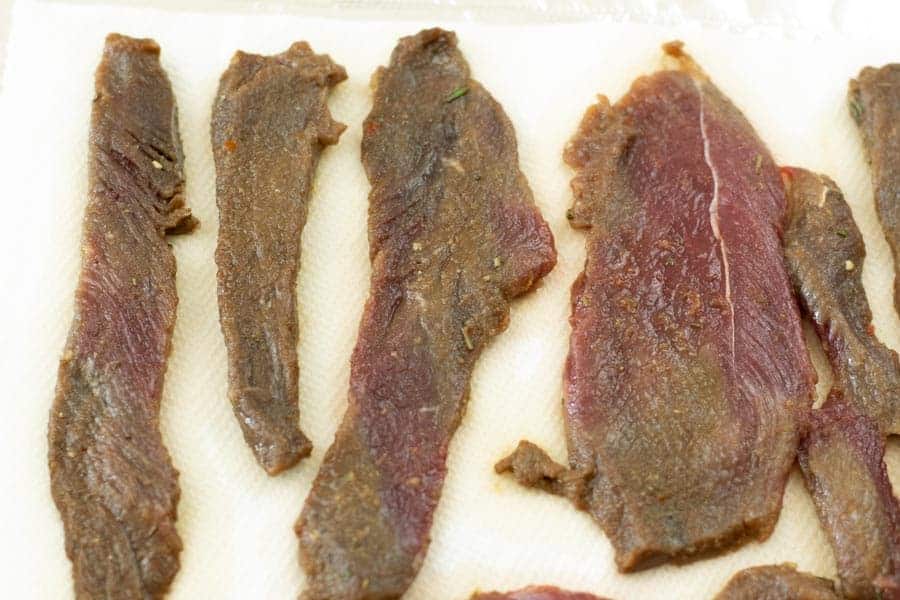 Venison jerky drying on paper towels