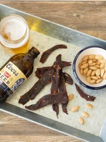 Deer jerky on tray with beer and nuts