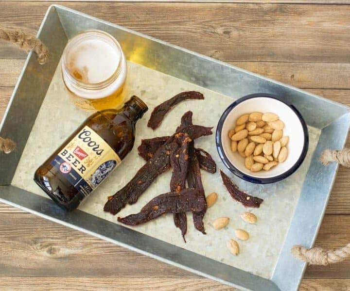 Deer jerky on tray with beer and nuts