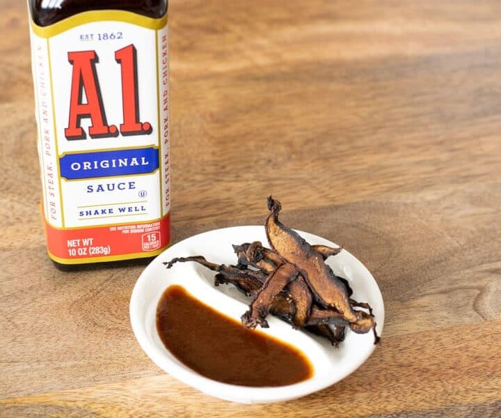 A1 sauce bottle and mushroom jerky on white plate on table