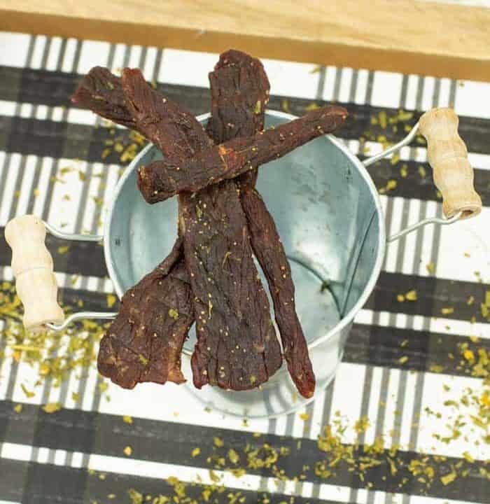 Beef jerky on bowl with checkered tray underneath
