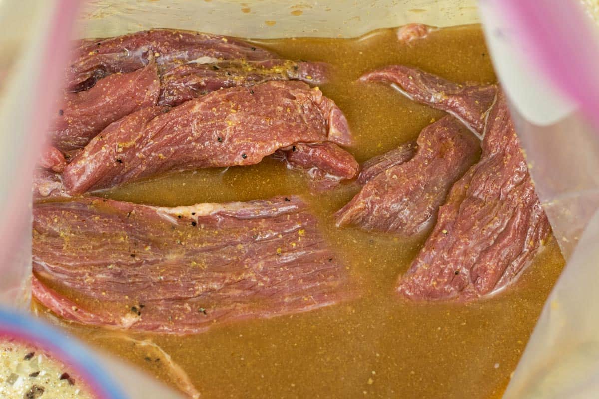 Beef jerky marinating in a tangy marinade.