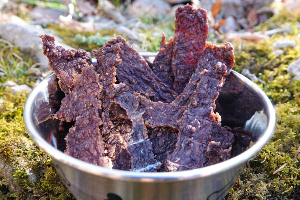 Dog jerky in bowl with grass in background