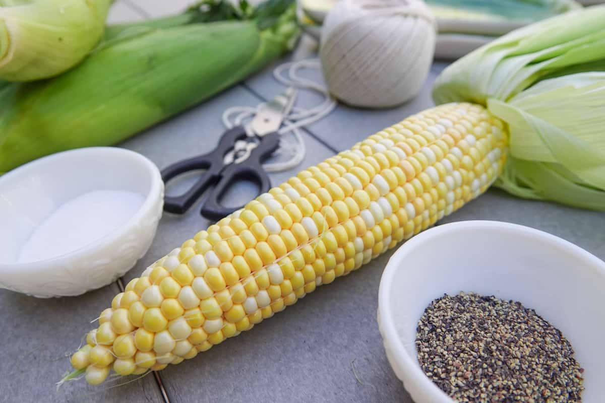 Ear of corn on table with salt and pepper