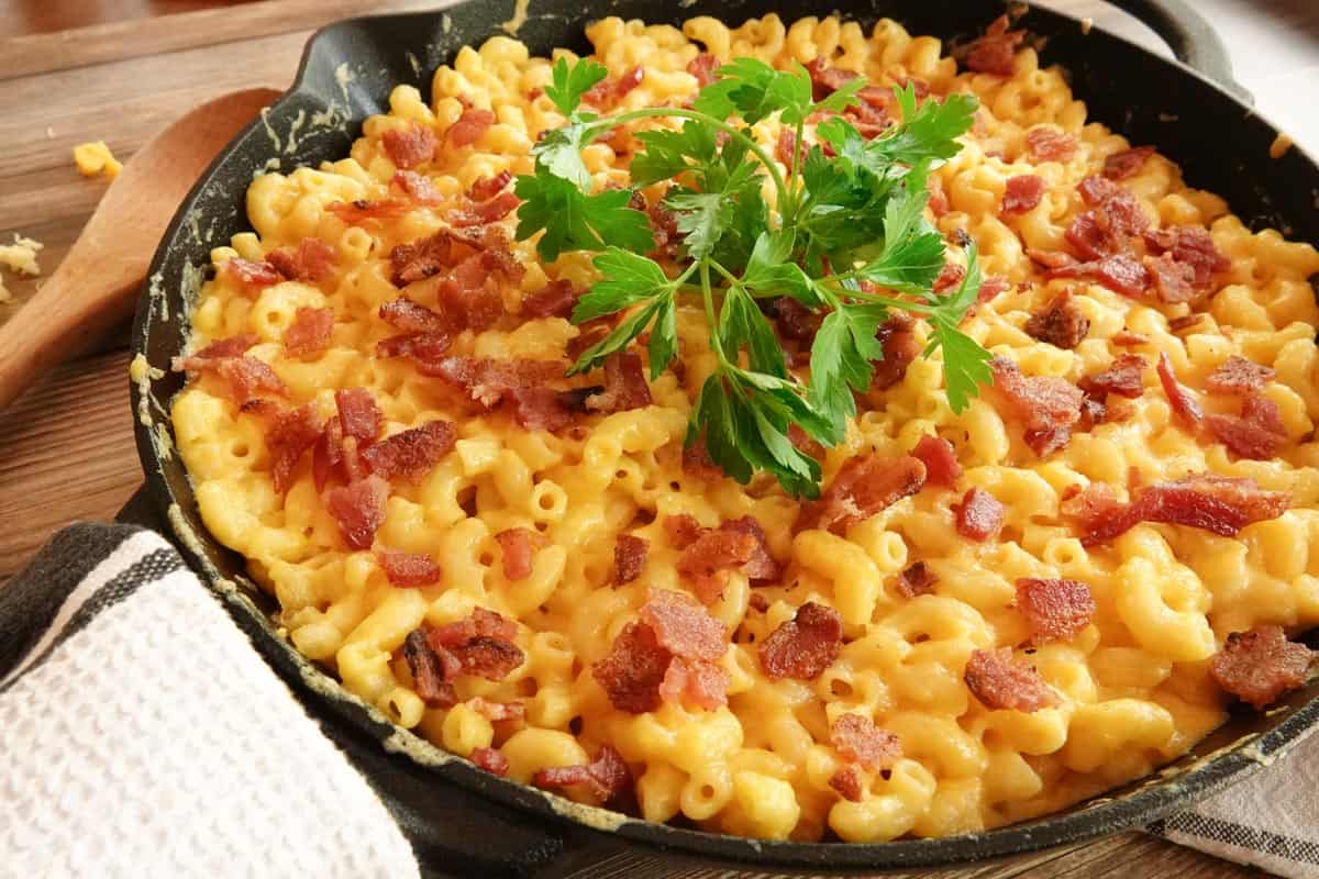 smoked mac and cheese in cast iron skillet with parsley garnish