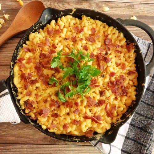 mac and cheese in cast iron skillet with spoon