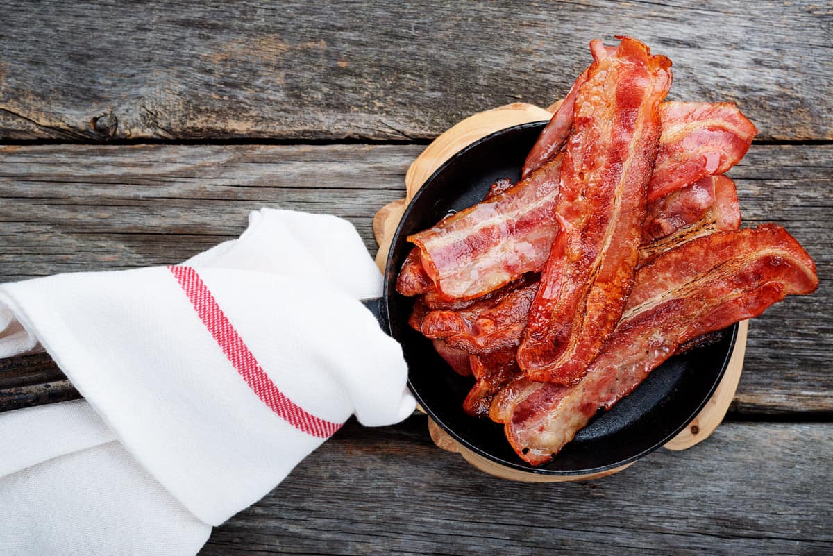 Bacon in frying pan with towel