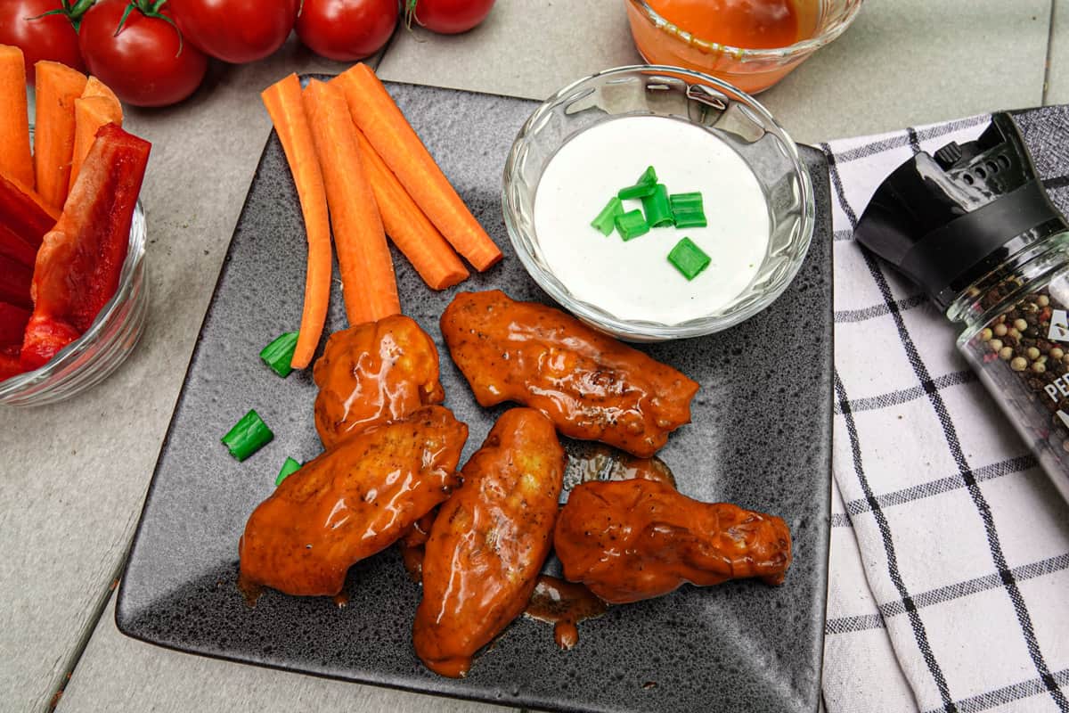 Chicken wings on plate with carrots and ranch dressing
