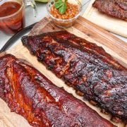 Two racks of ribs on cutting board with baked beans