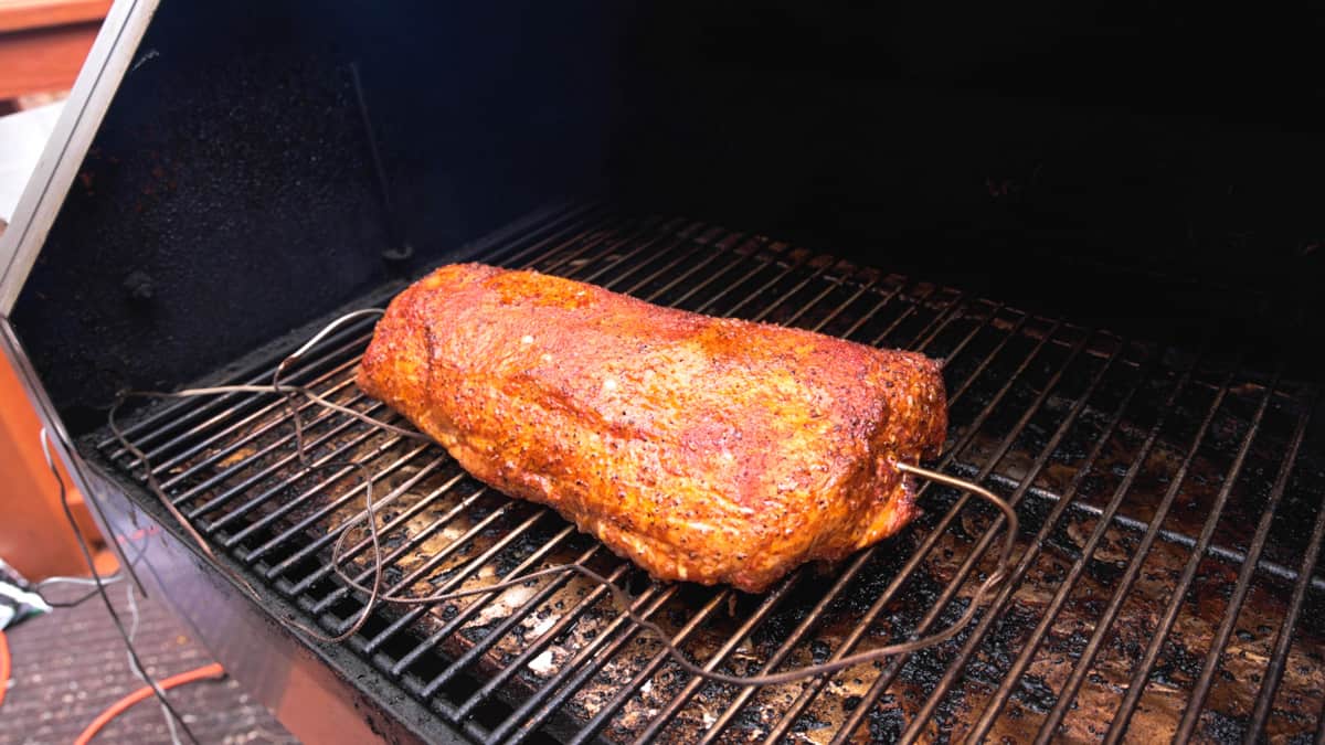 pork loin on smoker with two temperature probes in meat