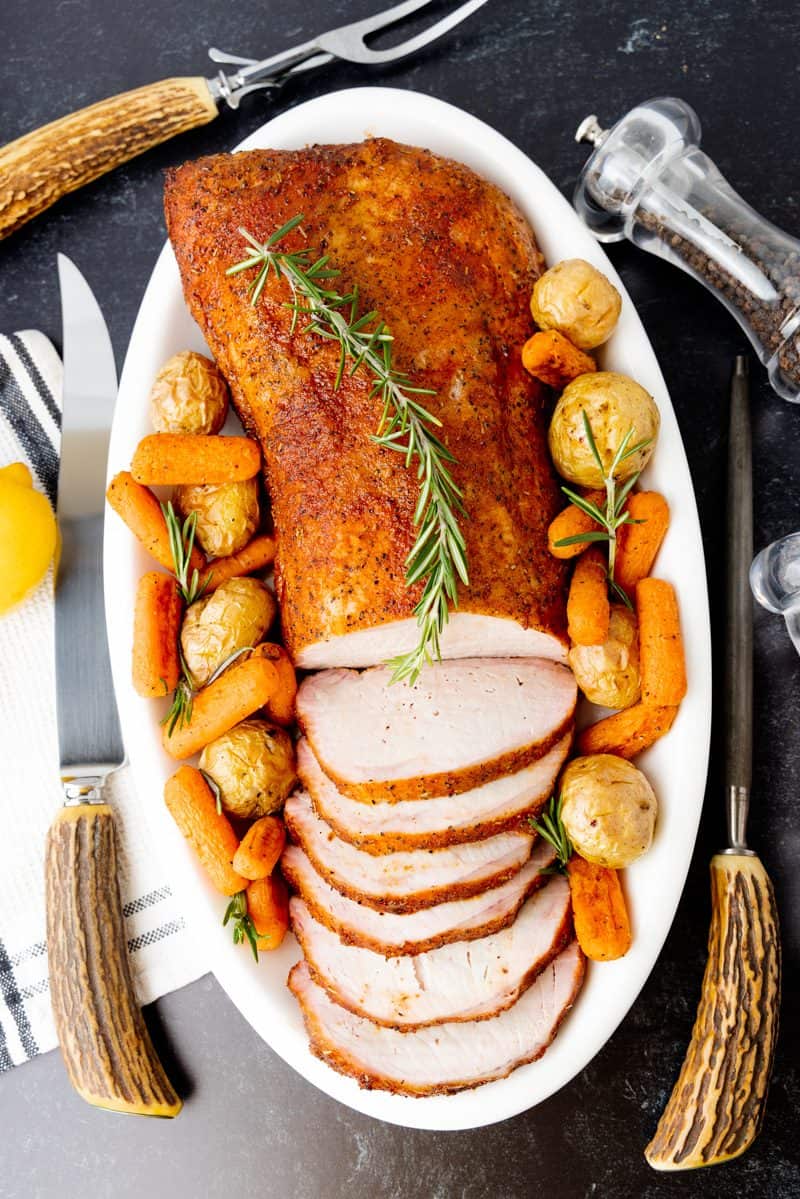 Pork loin on white dish with potatoes and carrots