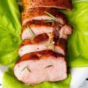 Pork tenderloin on bed of lettuce sliced with garnish