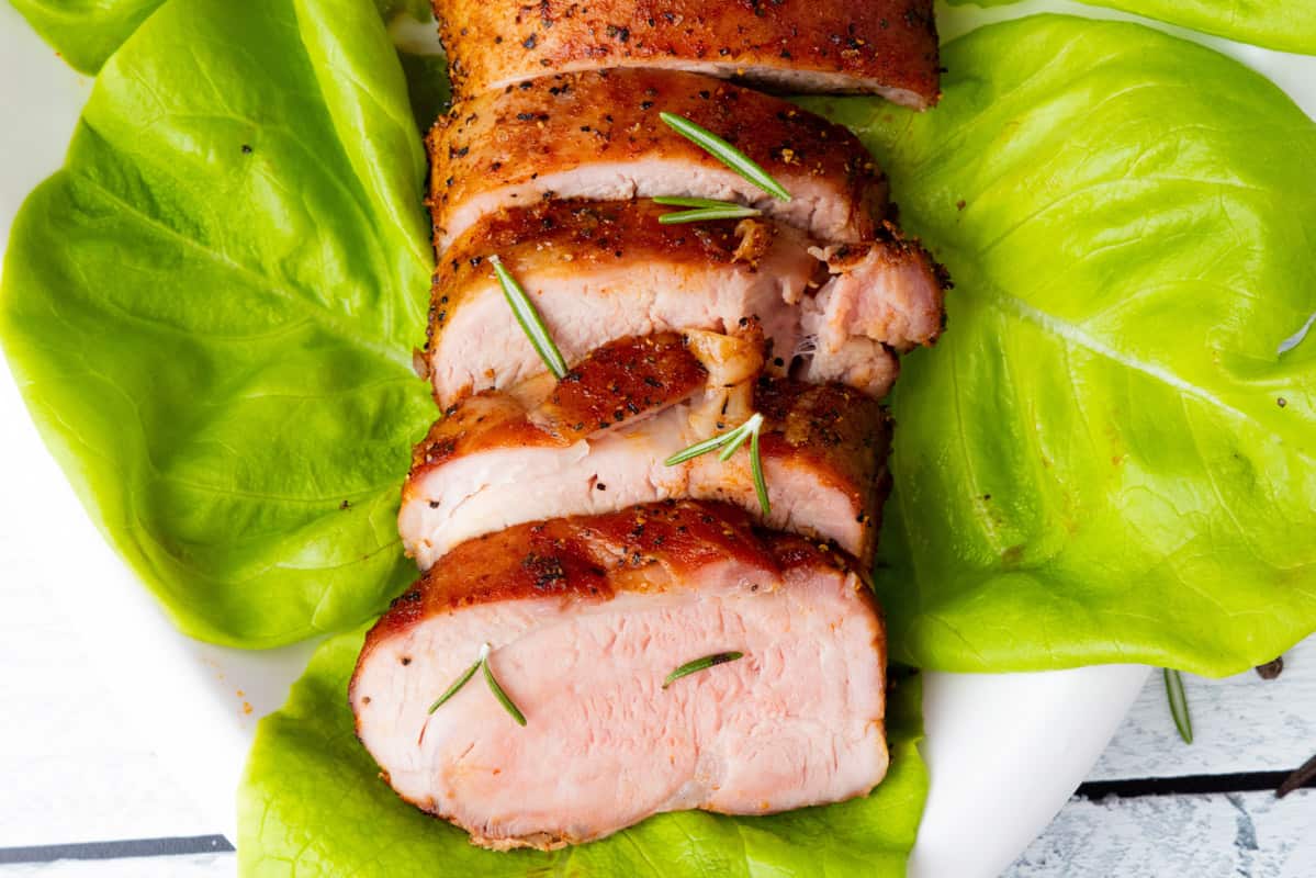 Pork tenderloin on bed of lettuce sliced with garnish