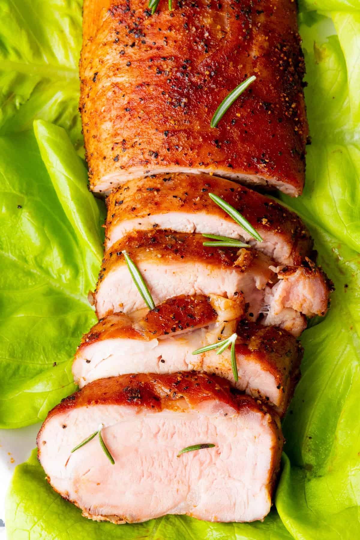 Pork tenderloin on bed of lettuce with garnish
