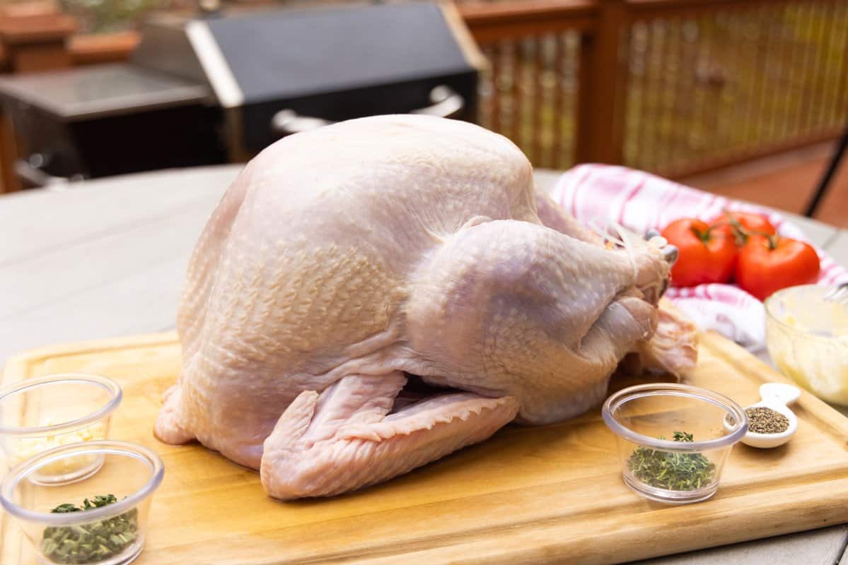 Turkey dried on cutting board with dishes of seasoning around turkey.