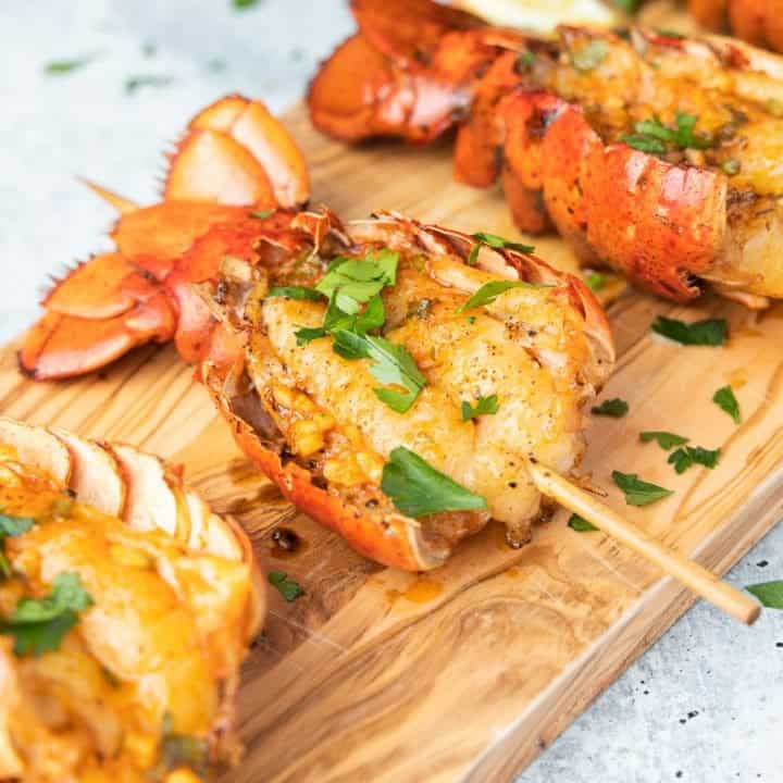 Smoked lobster tails on cutting board seasoned