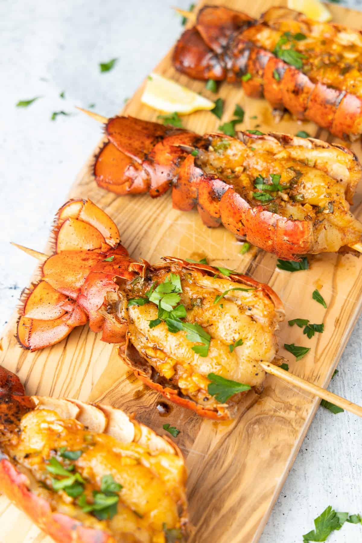 Lobster tails on cutting board seasoned with parsley