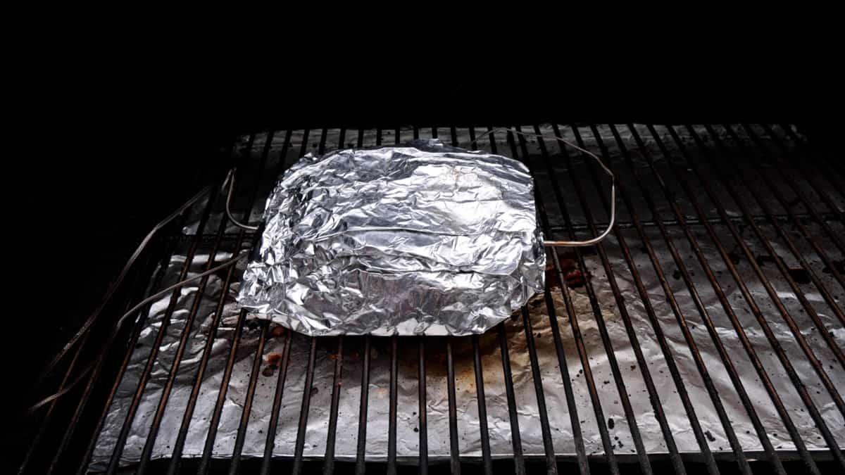 Foil wrapped corned beef on grill.